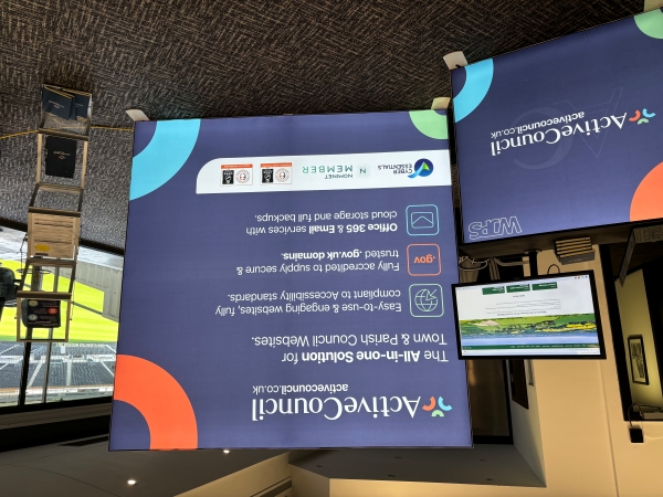 Active Council stand with banner in the background and a table with a screen attached.